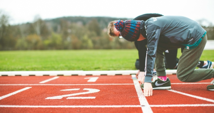 man in black and red plaid shirt and black pants standing on track field during daytime