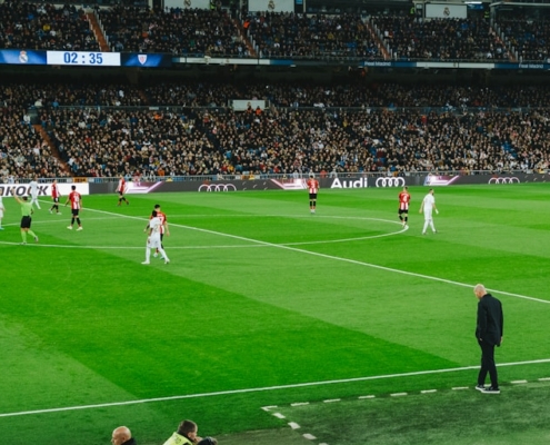 people watching soccer game during daytime