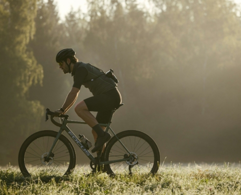 a man riding a bike through a lush green field