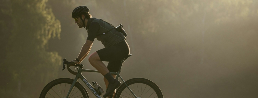 a man riding a bike through a lush green field